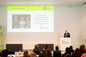 A Photograph of our YES 2025 Showcase with Professor Simon Mosey presenting on stage